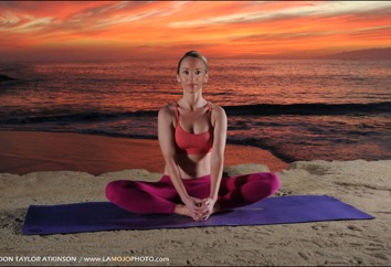 Erin McGurk practising a seated yoga pose on the beach at sunset